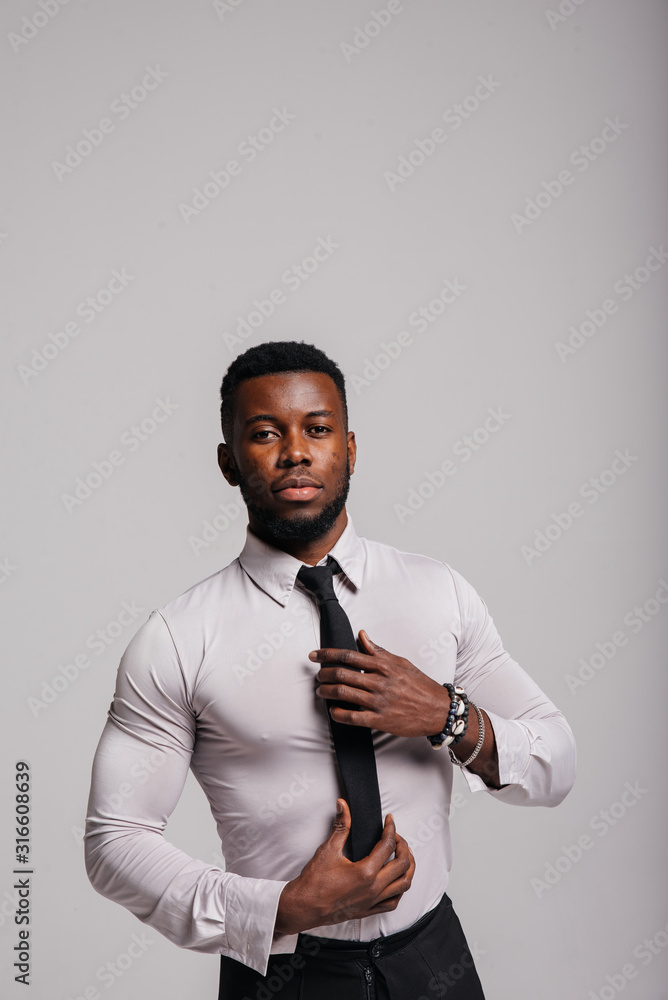 Happy confident young african american business male smiling with confidence, executive stylish company leader. Portrait of an businessman wearing suit and tie isolated on white background Happy confident young african american business male smiling with confidence, executive stylish company leader. Portrait of an businessman wearing suit and tie isolated on white background