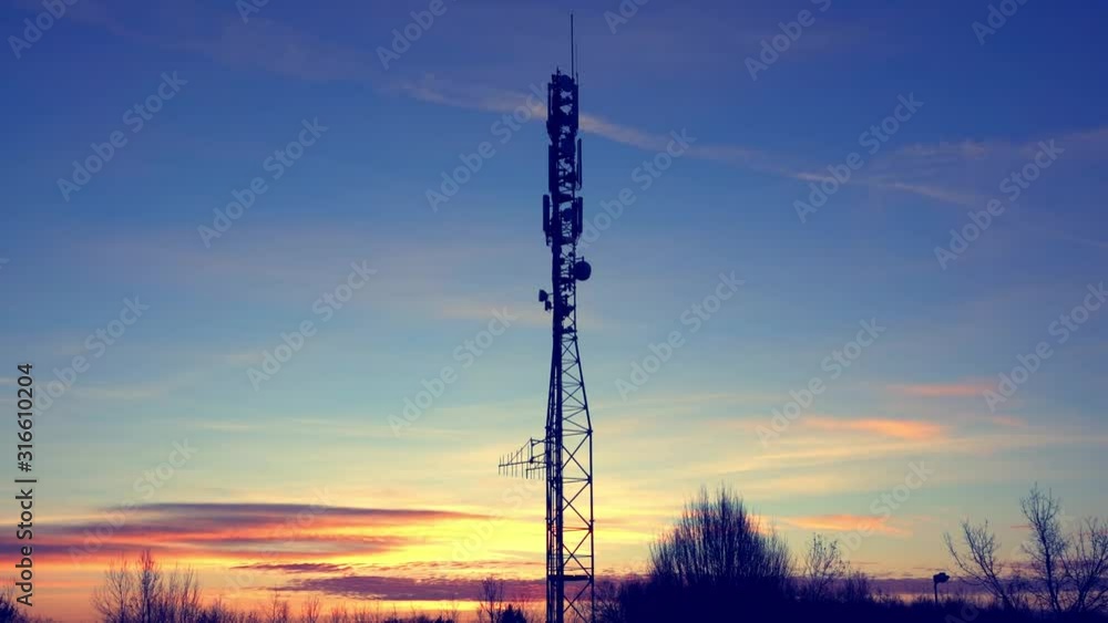 Communication tower for the antennas of mobile phone , television, Internet, radio, during morning sunrise with clouds in the fores Communication tower for the antennas of mobile phone , television, Internet, radio, during morning sunrise with clouds in the fores