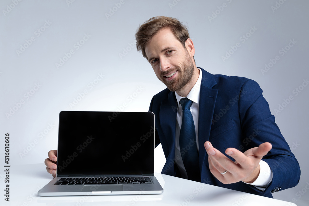 Positive businessman asking for an opinion and presenting his laptop Positive businessman asking for an opinion and presenting his laptop