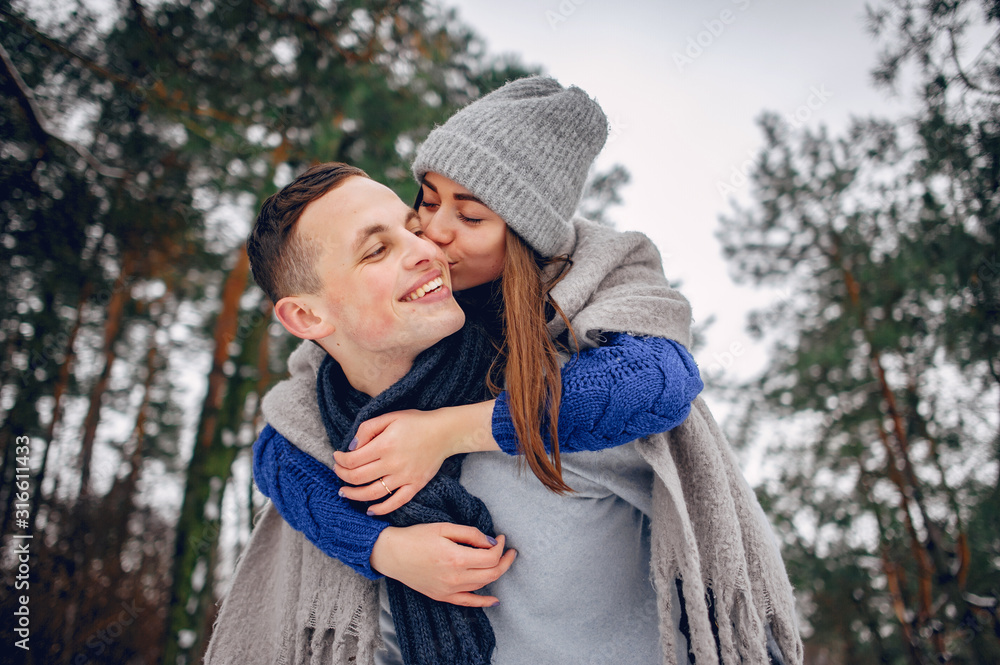 Couple in a winter forest. Beautiful girl in a blue sweater. Couple in a winter forest. Beautiful girl in a blue sweater.