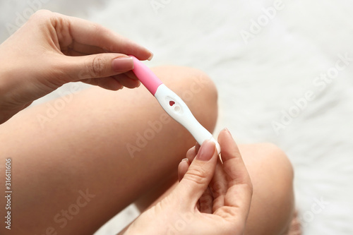 Young woman with pregnancy test in bathroom  closeup