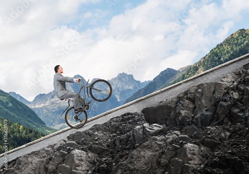 Fotografie, Obraz Businessman riding downhill by bike