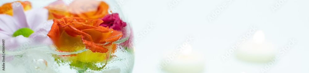 Roses in transparent vase with burning candles on white background, web banner Roses in transparent vase with burning candles on white background, web banner