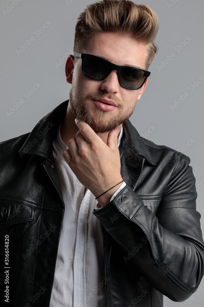 young fashion model in leather jacket touching beard young fashion model in leather jacket touching beard