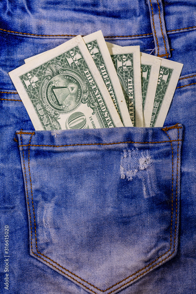 American one dollar banknotes in a pocket of blue jeans American one dollar banknotes in a pocket of blue jeans