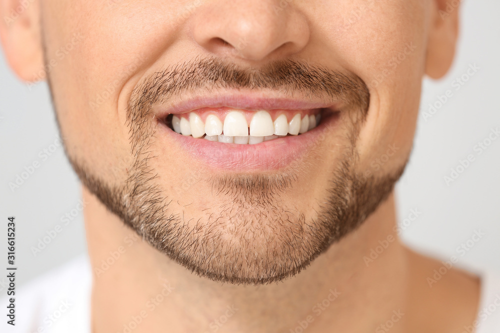 Fototapeta premium Handsome smiling man on light background, closeup