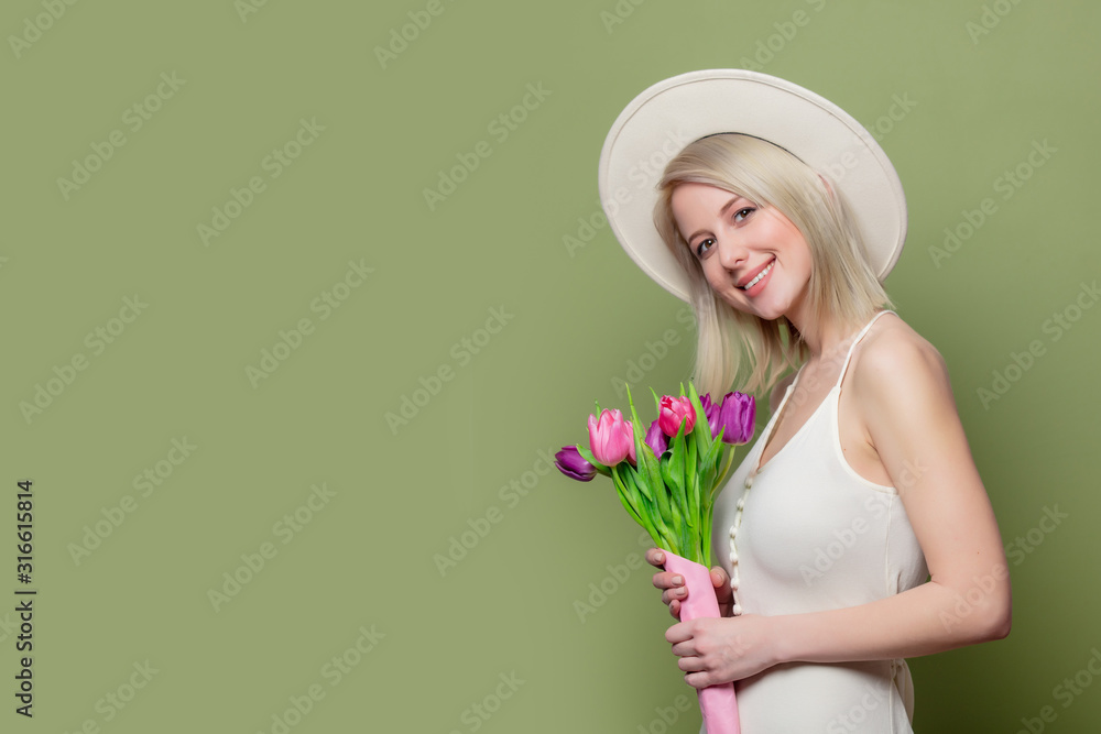 Beautiful blonde girl in white hat and dress with tulips Beautiful blonde girl in white hat and dress with tulips