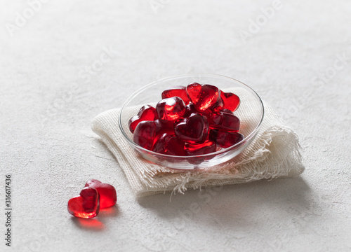 Fototapeta Naklejka Na Ścianę i Meble -  Jelly marmalade cherry hearts in a saucer on a white background