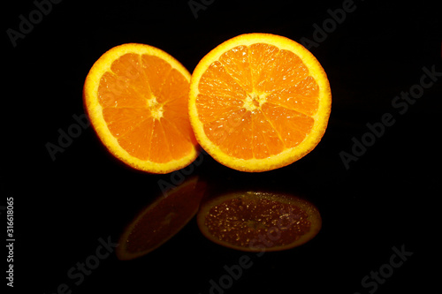 Two  half orange isolated on black with reflections