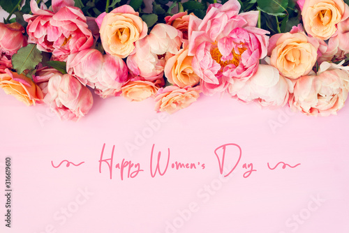 Fresh bunch of pink peonies and roses and text Happy Womens Day. Card Concept, pastel colors, close up image