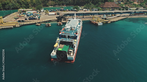 Aerial Top Drone Flight over Big Ferry Boat Sailing to the Island Harbor in Tropical Nusa Penida, Bali Island, Indonesia. Blue Crystal Water. Travel Vacation Tourism © Goinyk