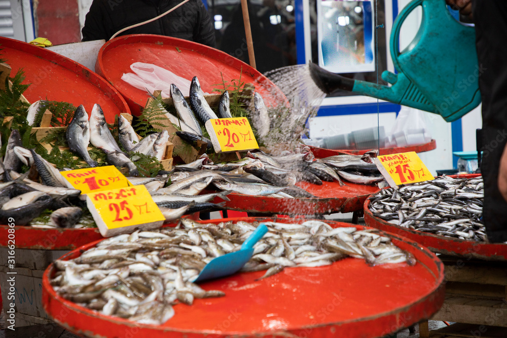 Fresh fish are sold at the market counter