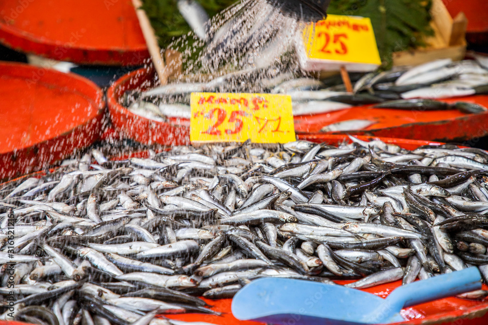 Fresh fish are sold at the market counter