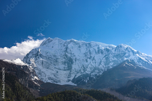Nepal snowy mountains against the blue sky with clouds © Tetiana