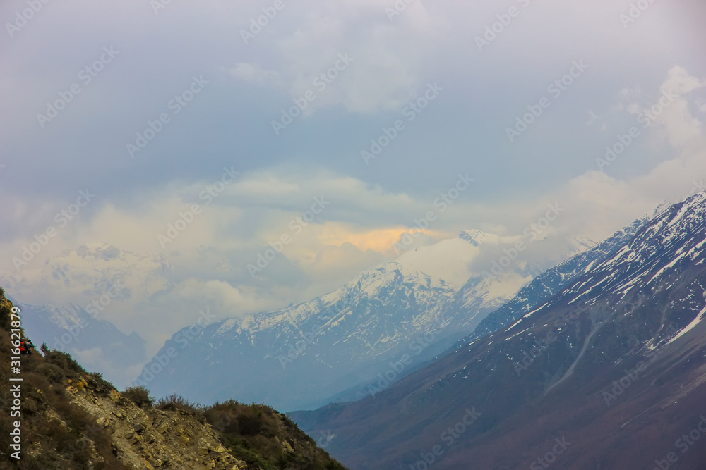 Fototapeta premium Nepal snowy mountains against the blue sky with clouds