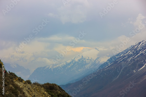 Nepal snowy mountains against the blue sky with clouds