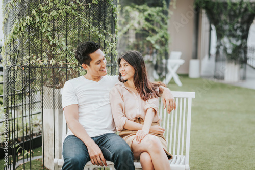Happy Asian couple smiling while sitting on the bench © interstid