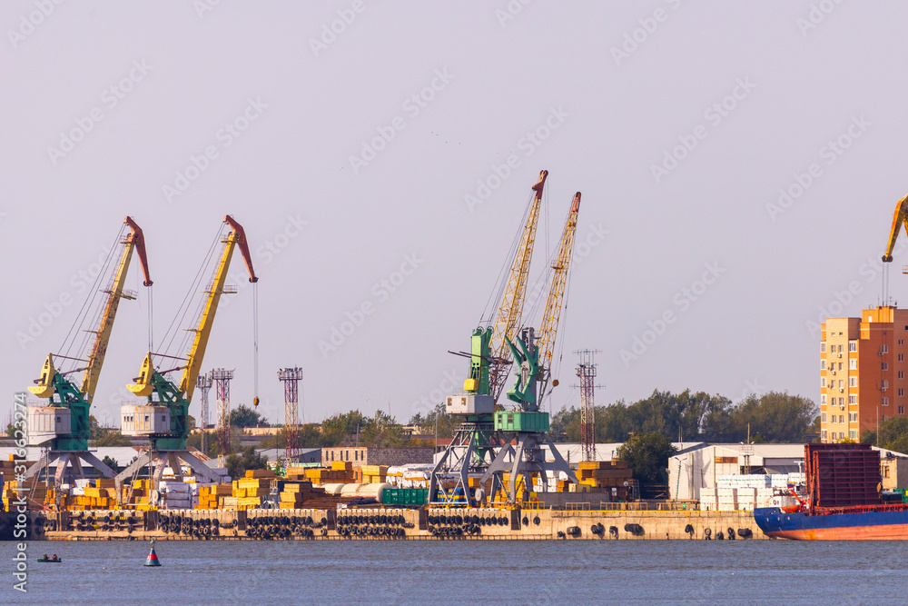 Industrial landscape with port cranes in the port on the background of the city view