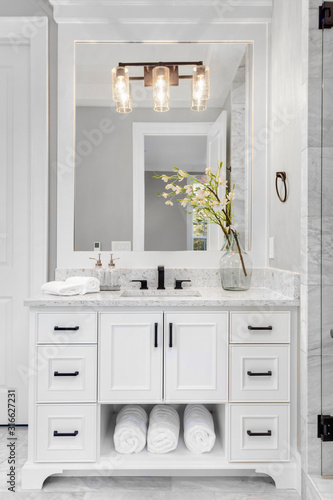 Bathroom in traditional style luxury home with vanity  mirror  sink  and tile floor