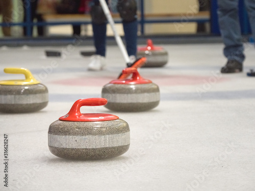 Curling stone on ice of a indoors rink.