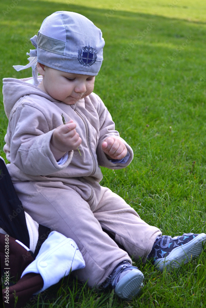 little boy sits on green grass on a picnic little boy sits on green grass on a picnic