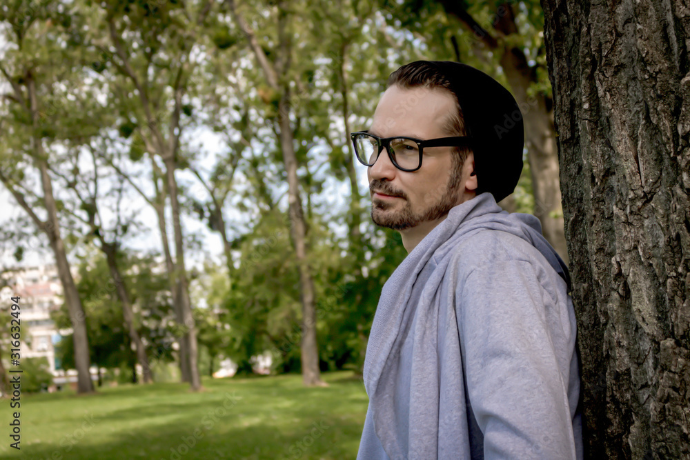 Portrait of pensive man leaning on a tree at the park. Portrait of pensive man leaning on a tree at the park.