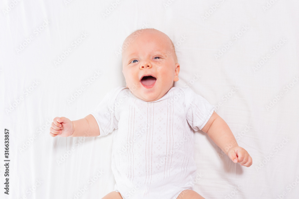 Laughing happy little infant baby boy with open mouth and shining eyes view from above Laughing happy little infant baby boy with open mouth and shining eyes view from above