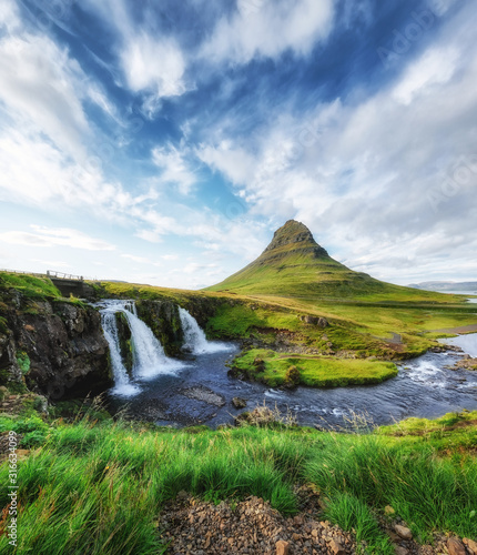 Kirkjufell. Mountains and waterfall in the Iceland. Natural landscape in the summer. Grass and river. Famous place. Iceland travel - image