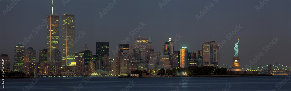 This is the downtown Manhattan skyline and Statue of Liberty. It is the view from New Jersey at dusk. The World Trade towers dominate the left hand side, the Statue of Liberty is on the right. - obrazy, fototapety, plakaty 