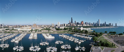 This is an aerial view of the Shedd Aquarium, Chicago Harbor and the skyline on Lake Michigan during summer. Boats are moored in the harbor in the foreground.