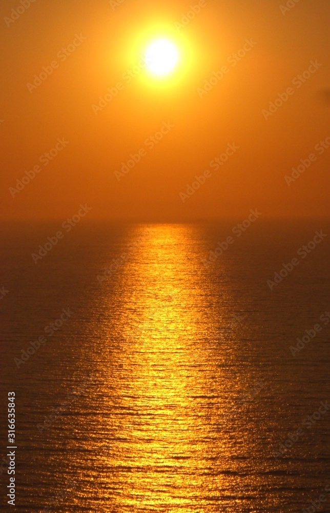 Sunset over the horizon of calm sea