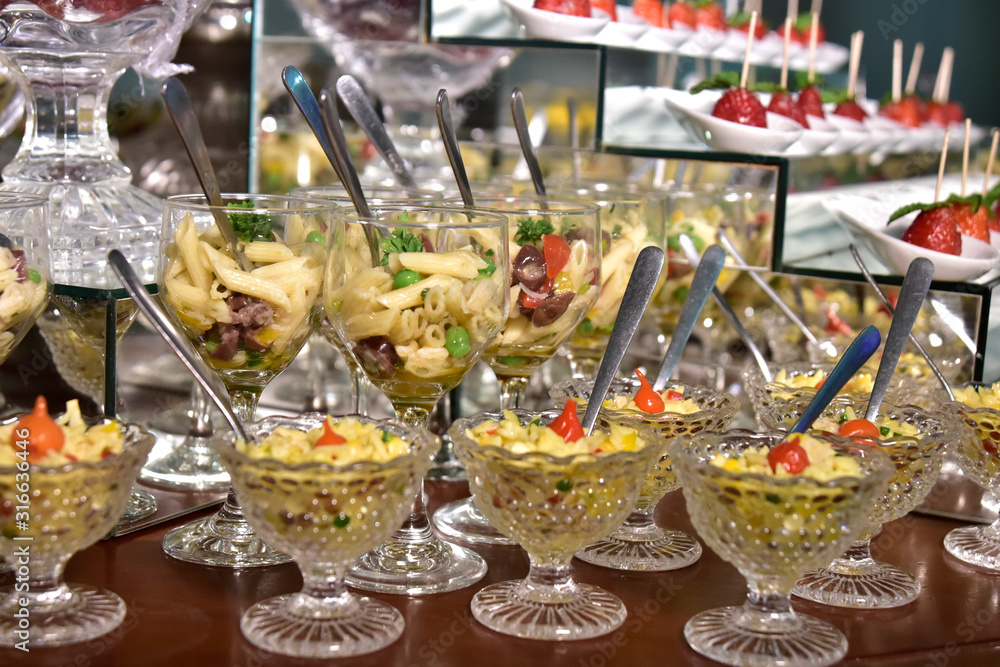 small portions of food pasta, salad, olive oil, spices in glass cups with blurs in the photo