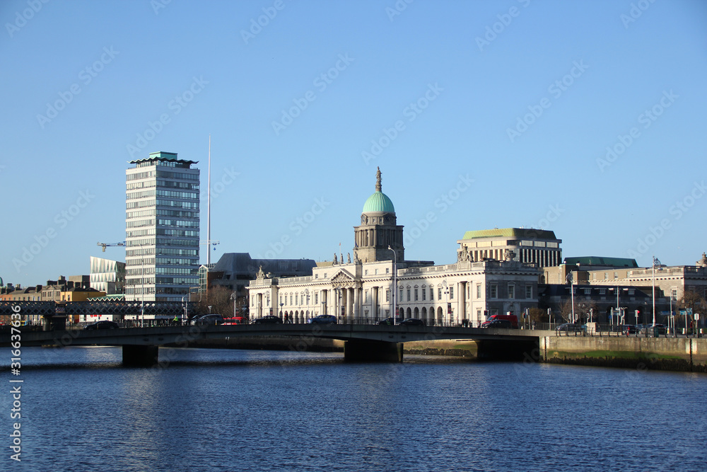 Dublin cityscape with the Liffey River and the old bridge, behind which you can see old buildings and modern skyscrapers, a concept of modern Europe