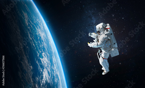 Astronaut in the outer space over the planet Earth. Abstract wallpaper. Spaceman. Elements of this image furnished by NASA