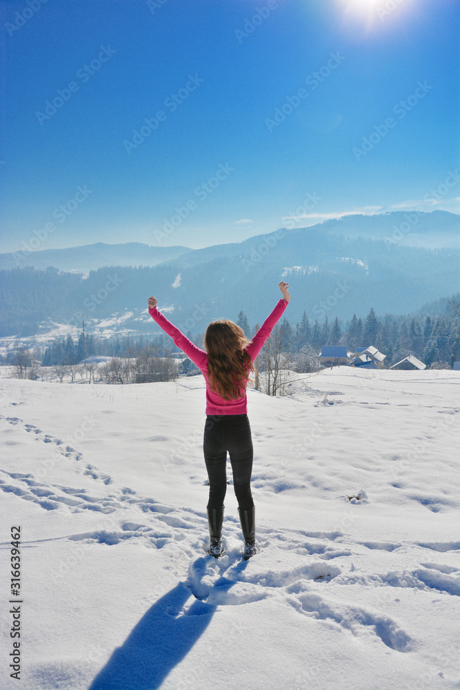 Ski traveler woman silhouette in amazing winter mountains landscape, over the clouds, opposite to sunset sky