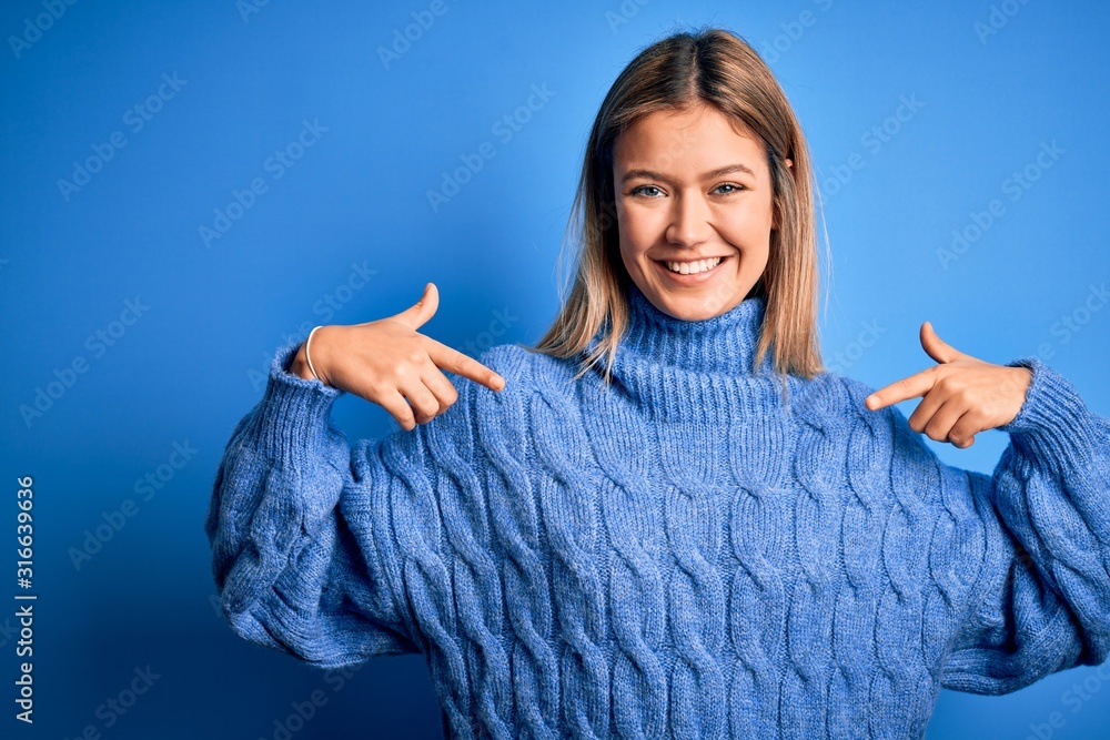 Young beautiful blonde woman wearing winter wool sweater over blue isolated background looking confident with smile on face, pointing oneself with fingers proud and happy. Young beautiful blonde woman wearing winter wool sweater over blue isolated background looking confident with smile on face, pointing oneself with fingers proud and happy.