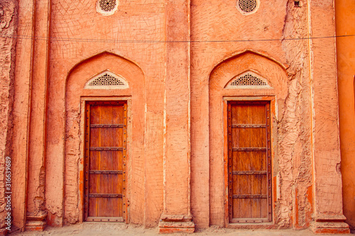Old red doors in village house in India © popovatetiana