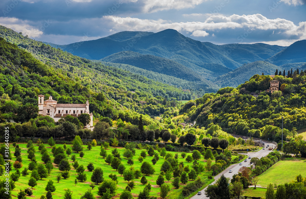 View of the green and beautiful Umbria countryside with the St Peter Extra Moenia ancient church from the city of Spoleto View of the green and beautiful Umbria countryside with the St Peter Extra Moenia ancient church from the city of Spoleto
