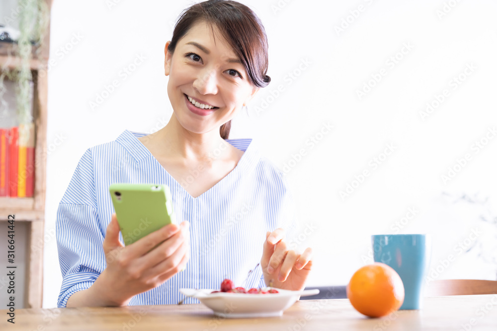 部屋でスマホを見る女性 部屋でスマホを見る女性