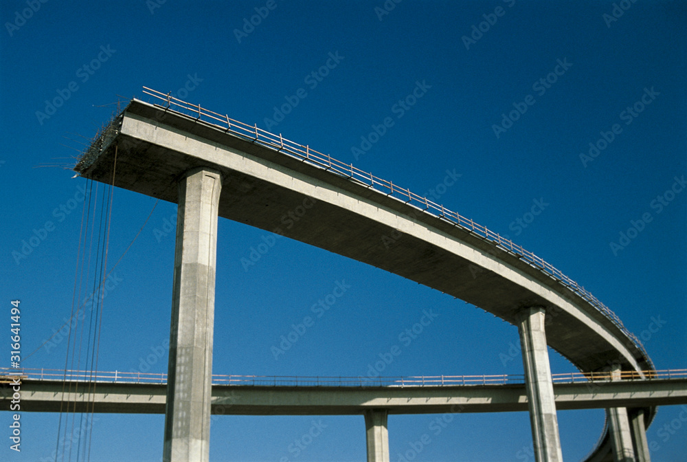 This shows a freeway under construction. It is the end of the road. The upper level of the road curves around and then just completely ends in mid-air. This shows a freeway under construction. It is the end of the road. The upper level of the road curves around and then just completely ends in mid-air.