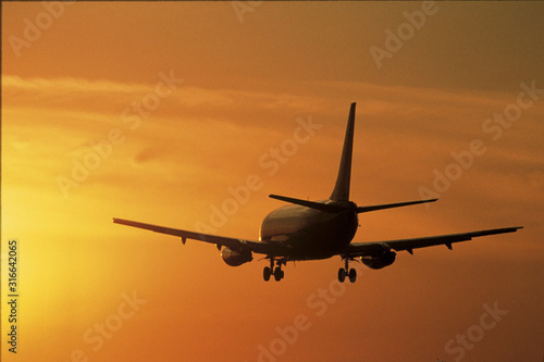This is a jet taking off into the sunset. It is at the LAX Airport in Los Angeles.