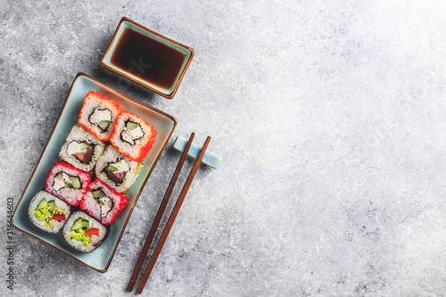 japanese sushi food. Rolls with tuna, salmon, shrimp, crab and vegetables. Top view of assorted sushi. Rainbow sushi roll on stone background. Flat lay