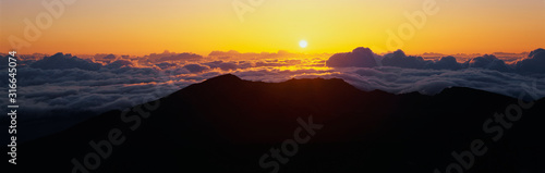 This is sunrise from Haleakala Volcano Summit located at Haleakala National Park. These are the cloud formations over the top of the volcano.