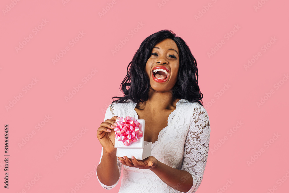 Portrait of young happy woman having a great reaction while opening a birthday, anniversary or valentineÕs day romantic gift Portrait of young happy woman having a great reaction while opening a birthday, anniversary or valentineÕs day romantic gift