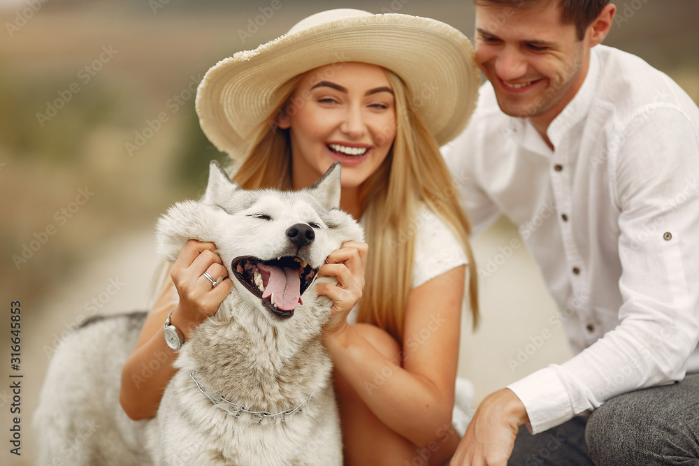 Couple in a field. Pair with a dog. Girl in a white dress Couple in a field. Pair with a dog. Girl in a white dress