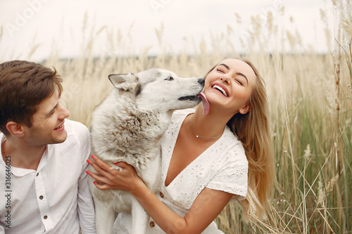 Couple in a field. Pair with a dog. Girl in a white dress