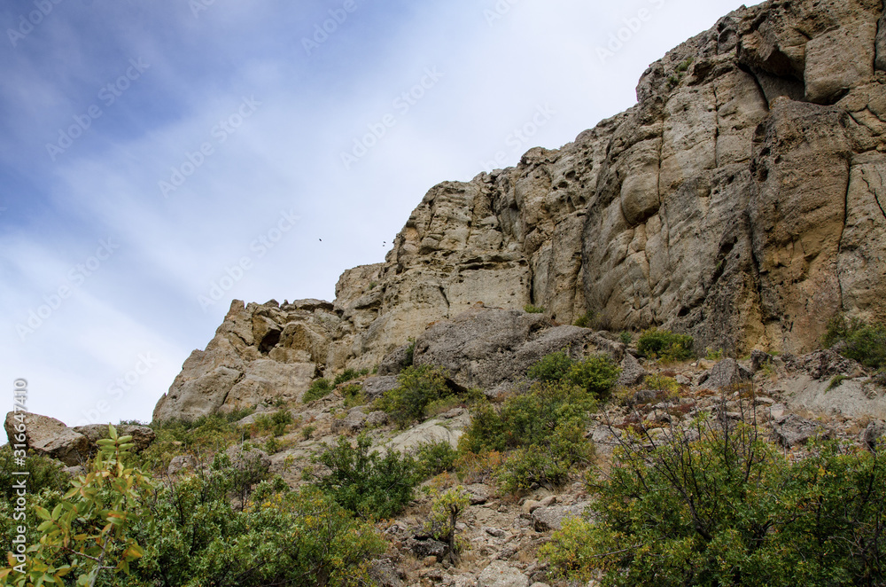 Mountain landscape. Sheer cliff and sky. Travel and adventure.