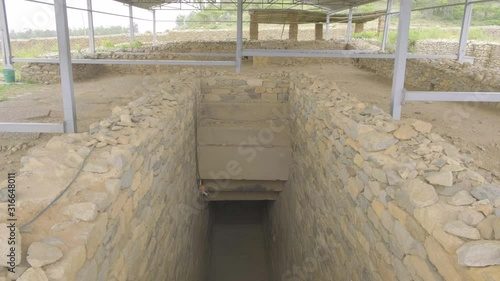 Camera tilt down to reveal entrance and underground stairs into the Tomb of King Gebre Meskel in Aksum, Ethiopia photo