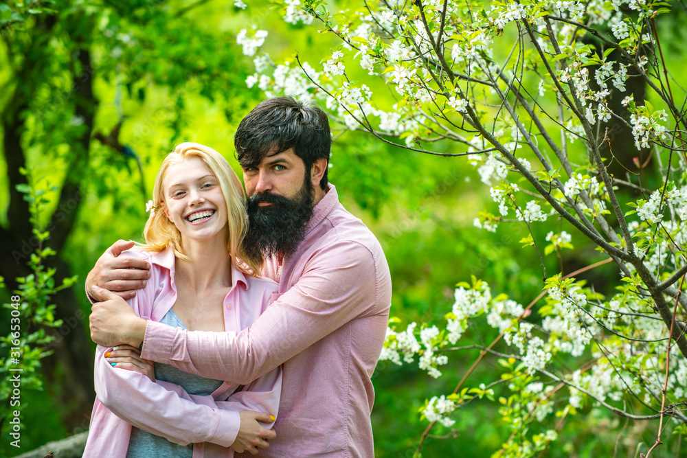 Pretty woman and handsome man walking in the spring Park and enjoying the beautiful spring blossom nature. Pretty woman and handsome man walking in the spring Park and enjoying the beautiful spring blossom nature.