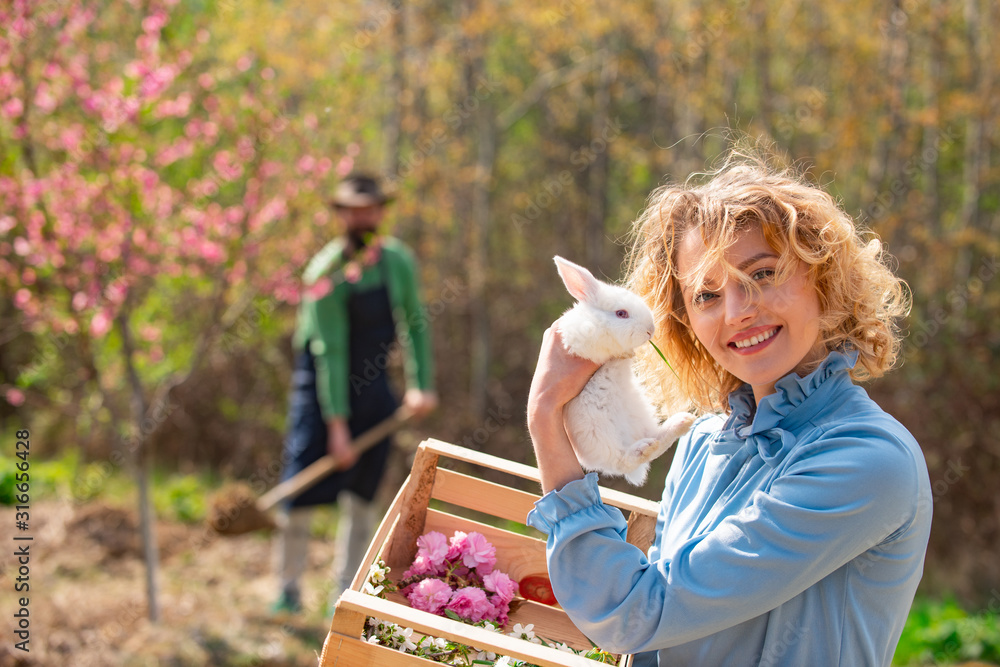 Closeup of winking girl with bunny rabbit. Portrait of young woman posing with rabbit. Closeup of winking girl with bunny rabbit. Portrait of young woman posing with rabbit.